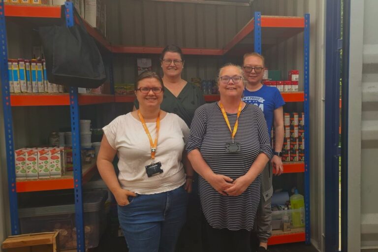 Four Quids In volunteers standing in front of one of their affordable food clubs