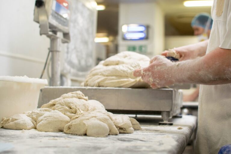 bakery with a baker weighing pieces of dough