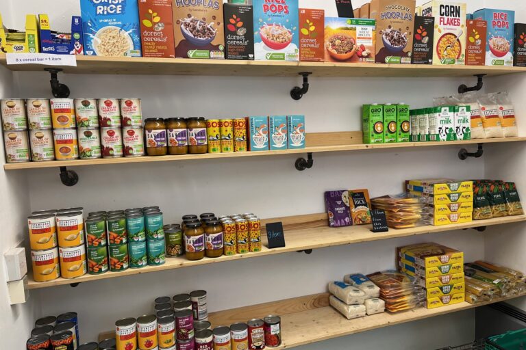 Gorton community Grocer - shelves filled with packets, jars and tins of food.