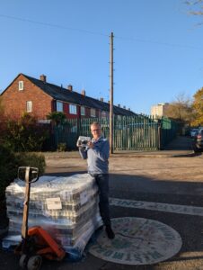 Martin Henderson, headtecher at Westmorland Primary standing holding a tray of donated milk