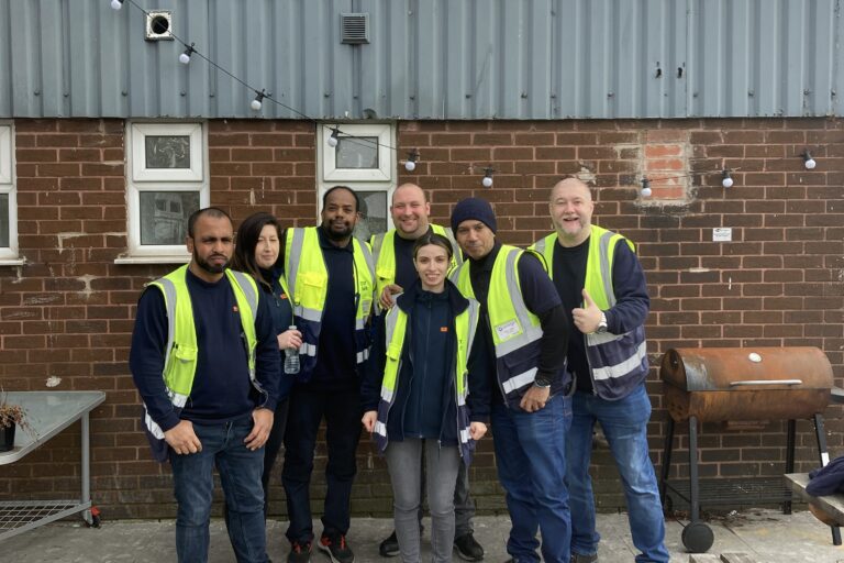 Image shows a group of N Brown collegues posing for a photo outside FareShare Greater Manchester while on a corporate volunteering day