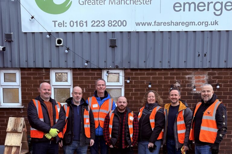 Image shows group photo of a team of seven N Brown colleagues on a corporate volunteering day at FareShare Greater Manchester