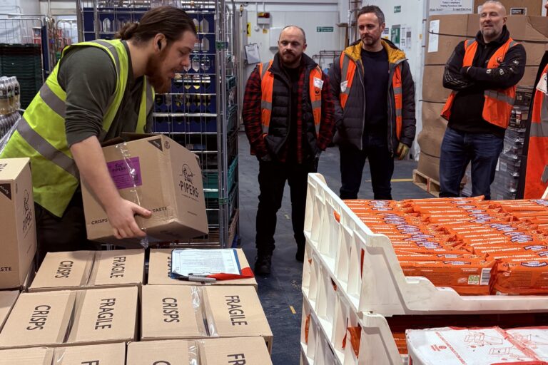 Image shows group of N Brown corporate volunteers being given a safety briefing in the warehouse at FareShare Greater Manchester.