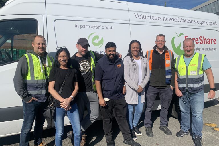 Image shows a group of N Brown Colleagues standing by the side of a FareShare Greater Manchester delivery van