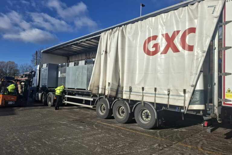 photo shows a large GXO lorry with the side curtain pulled back to show fridges on board.