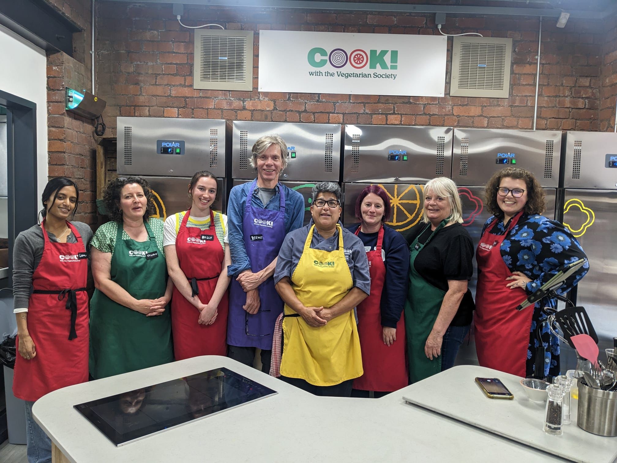 Image shows FareShare Greater Manchester Staff with Vegetarian Society chef, Maz in the Vegetarian Society Workshop