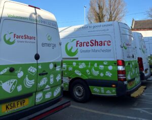 Image shows a row of FareShare Greater Manchester vans parked in a row